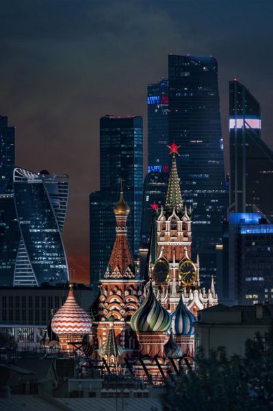Вид на деловой центр «Москва-Сити» через башни московского Кремля на закате