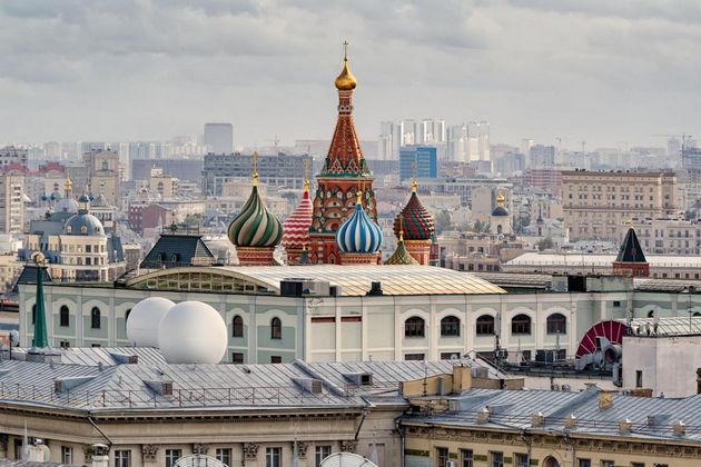 A view of the domes of the Saint Basil’s Cathedral in the Red Square in the background of the city roofs