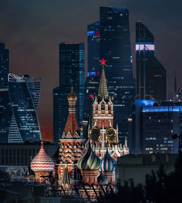 Вид на деловой центр «Москва-Сити» через башни Московского Кремля на закате